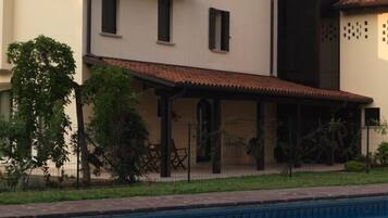 A two-story house with a swimming pool in the foreground.