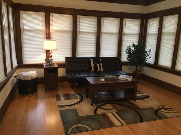 A living room with a black sofa, a wooden coffee table, a lamp, and a potted plant.