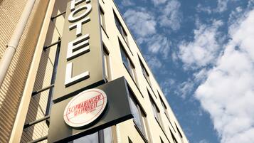 A hotel sign with the name "SCHWABINGER WAHRHEIT" and a logo.