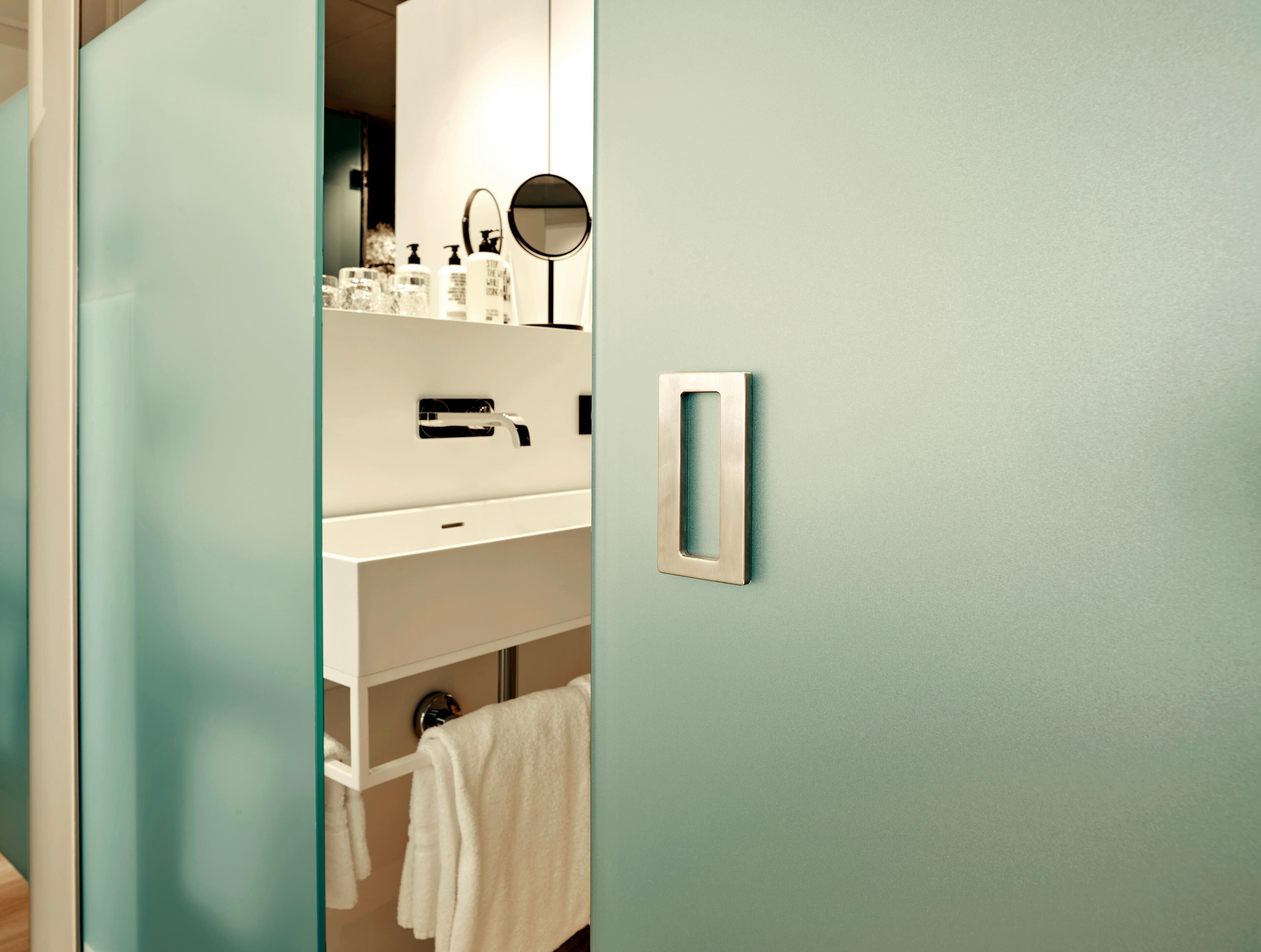 Une salle de bain avec un lavabo blanc, un miroir et un porte-serviettes.