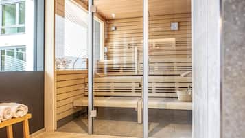 A modern bathroom with a glass partition, wooden slats, a bench, and a towel on a small table.