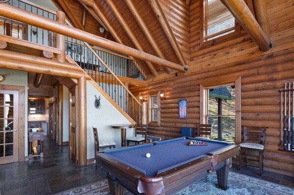 Relax in a spacious room with a pool table and enjoy the view from the large window with blinds.