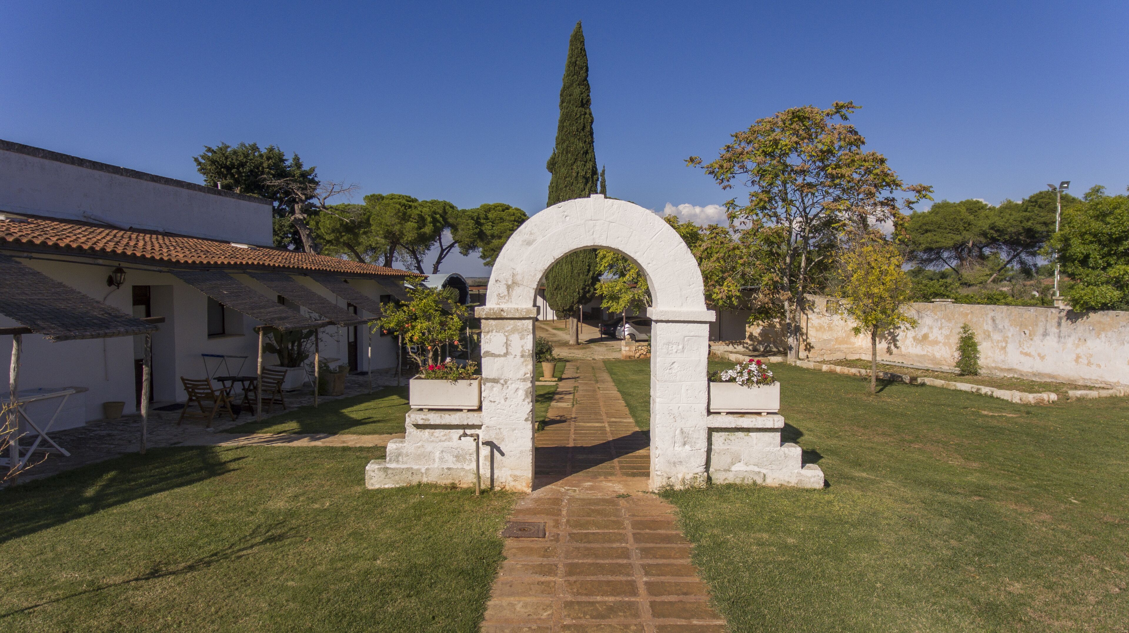 Un cortile con un arco in pietra che conduce a un edificio con tetto in tegole.