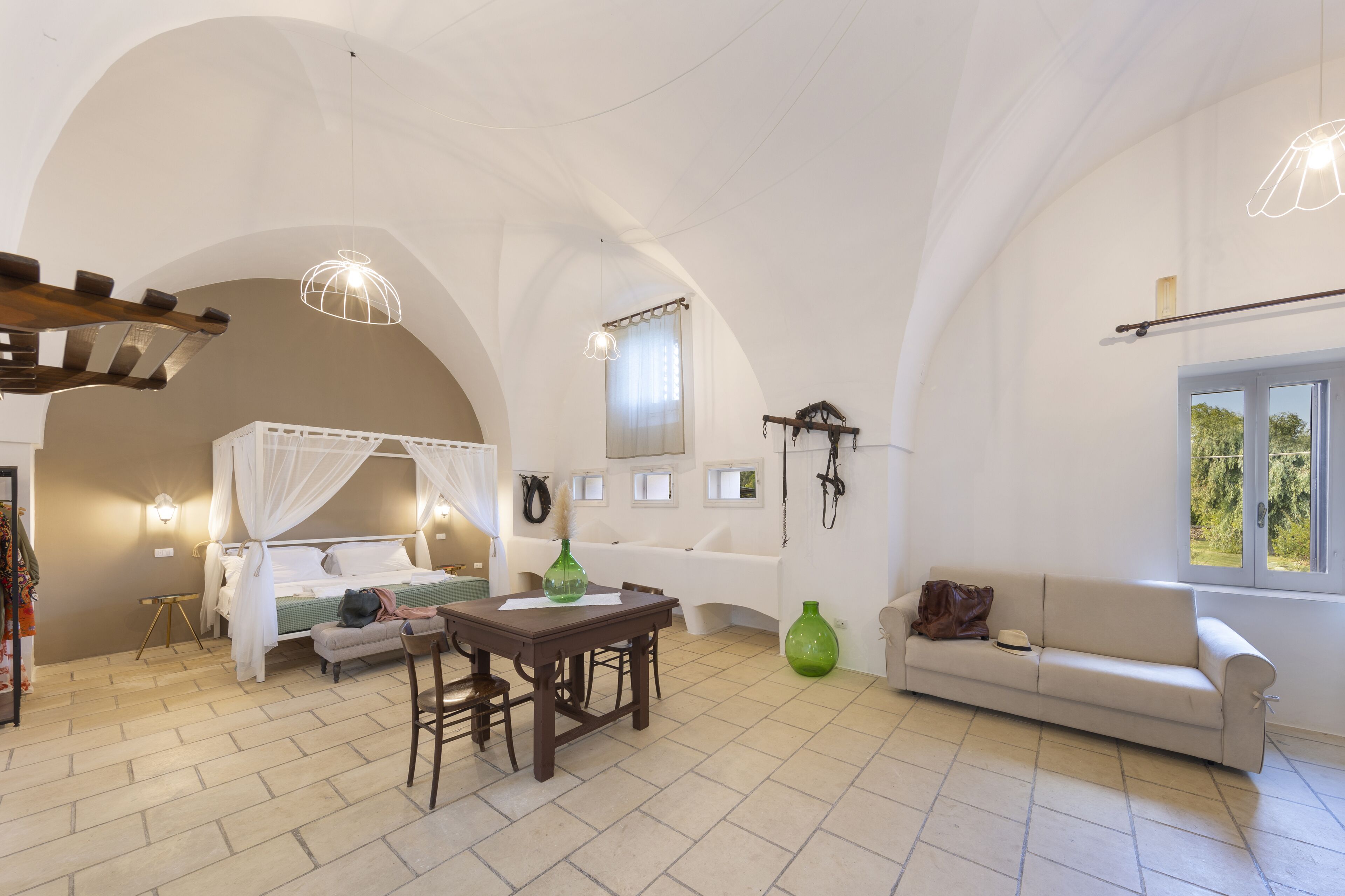Ein Schlafzimmer mit Bett, Sofa, Tisch und Fenster.