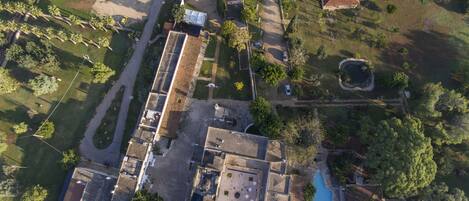 Vista aérea de una zona residencial con piscina, varias casas y un amplio espacio abierto.