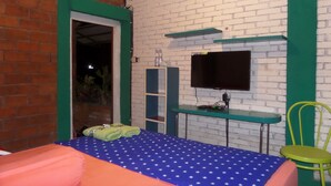 Ein Zimmer mit Bett, Schreibtisch, Fernseher und Stuhl.