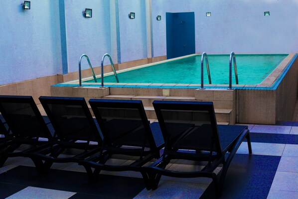 Alberca al aire libre y camastros
