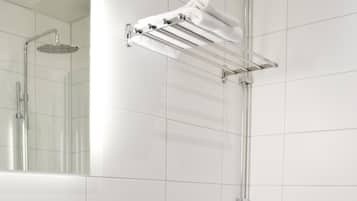 A modern bathroom with a white sink, toilet, and a glass shower enclosure.