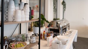 A buffet setup with various food items and utensils. - Hotell Stortorget (Östersund)