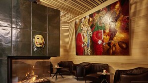 Un área de estar moderna con sofás de cuero, una chimenea y un mural grande en la pared.