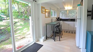 Una cocina con comedor, refrigerador y vistas al exterior.