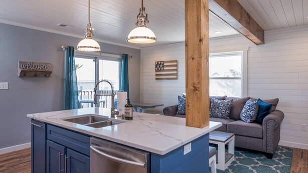 A modern kitchen with a central island, built-in appliances, and pendant lighting.