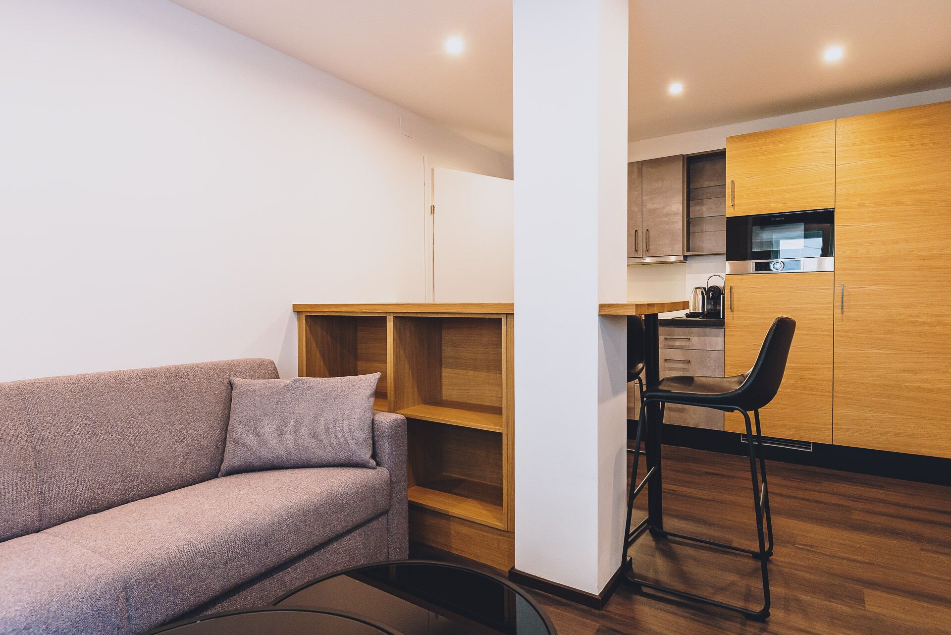 Un salon moderne avec un canapé et un coin repas comprenant une chaise et une table.