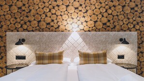 Une chambre d’hôtel avec un lit, deux oreillers et une tête de lit ornée d’un motif matelassé.