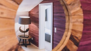 Un couloir avec un plancher en bois, une lampe et une petite table.