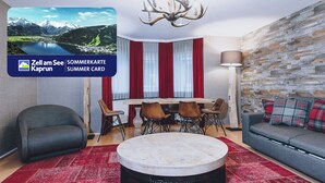Un salon moderne avec une table basse ronde, un canapé et un coin repas avec des chaises.
