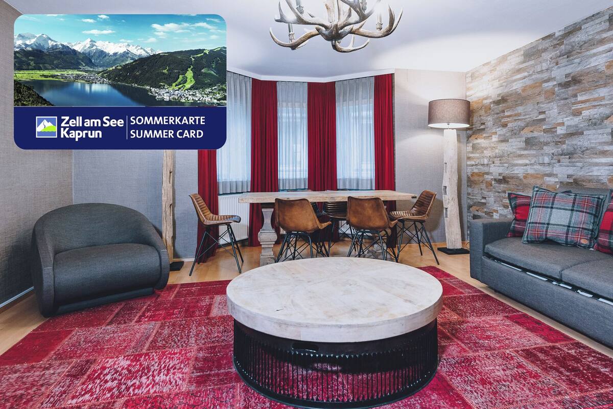 Un salon moderne avec une table basse ronde, un canapé et un coin repas avec des chaises.