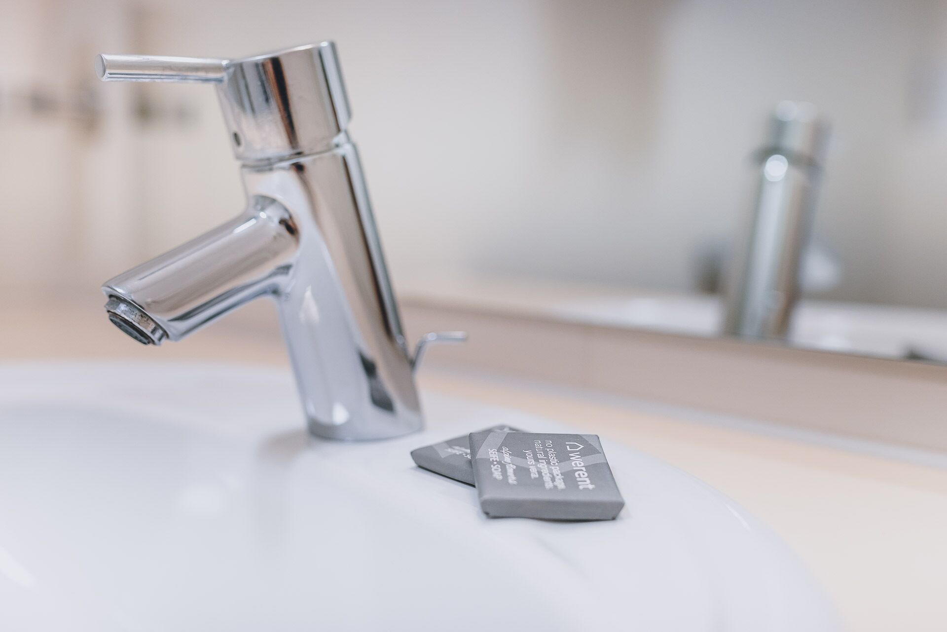 A bathroom sink with a chrome faucet and a soap dispenser.