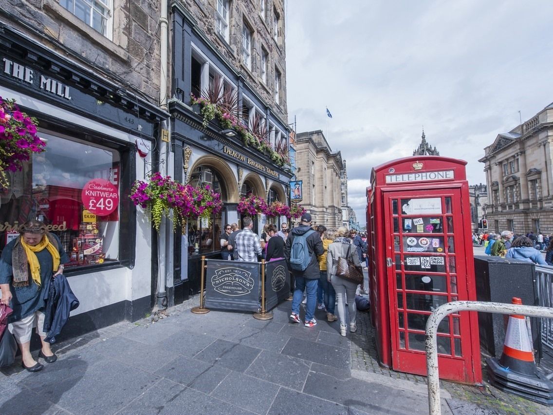 A street scene with a shop named "The Mill" and a red telephone booth.