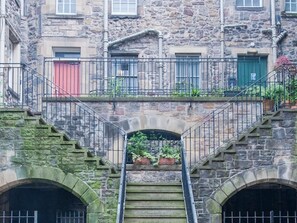 A stone staircase leading to a building with multiple doors, each with a different color. - Writers View (Edinburgh)
