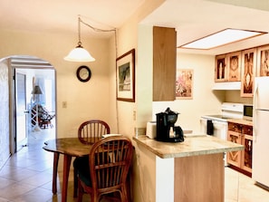 Enjoy meals at the dining table with a coffee maker and refrigerator nearby.