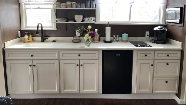 A compact kitchen with a dishwasher, a coffee maker, and a sink.