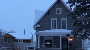 A two-story house with a snow-covered roof and a porch.