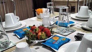 A breakfast setup with white cups, saucers, and a plate of strawberries. - Beatrice Home B&B (Pompei)
