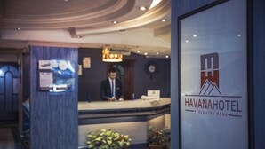 A reception desk with a sign reading "HAVANAHOTEL FEELS LIKE HOME". - Havana Hotel Cairo (Giza)