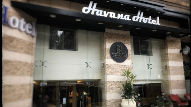 The exterior of Havana Hotel with a prominent sign, a large potted plant, and a visible entrance. - Havana Hotel Cairo (Giza)
