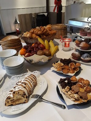 A buffet table with various food items including pastries, fruits, and desserts. - Gutshof im Oertzetal (Südheide)