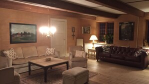 Una sala de estar acogedora con sofá, sillones, una mesa de centro y chimenea.
