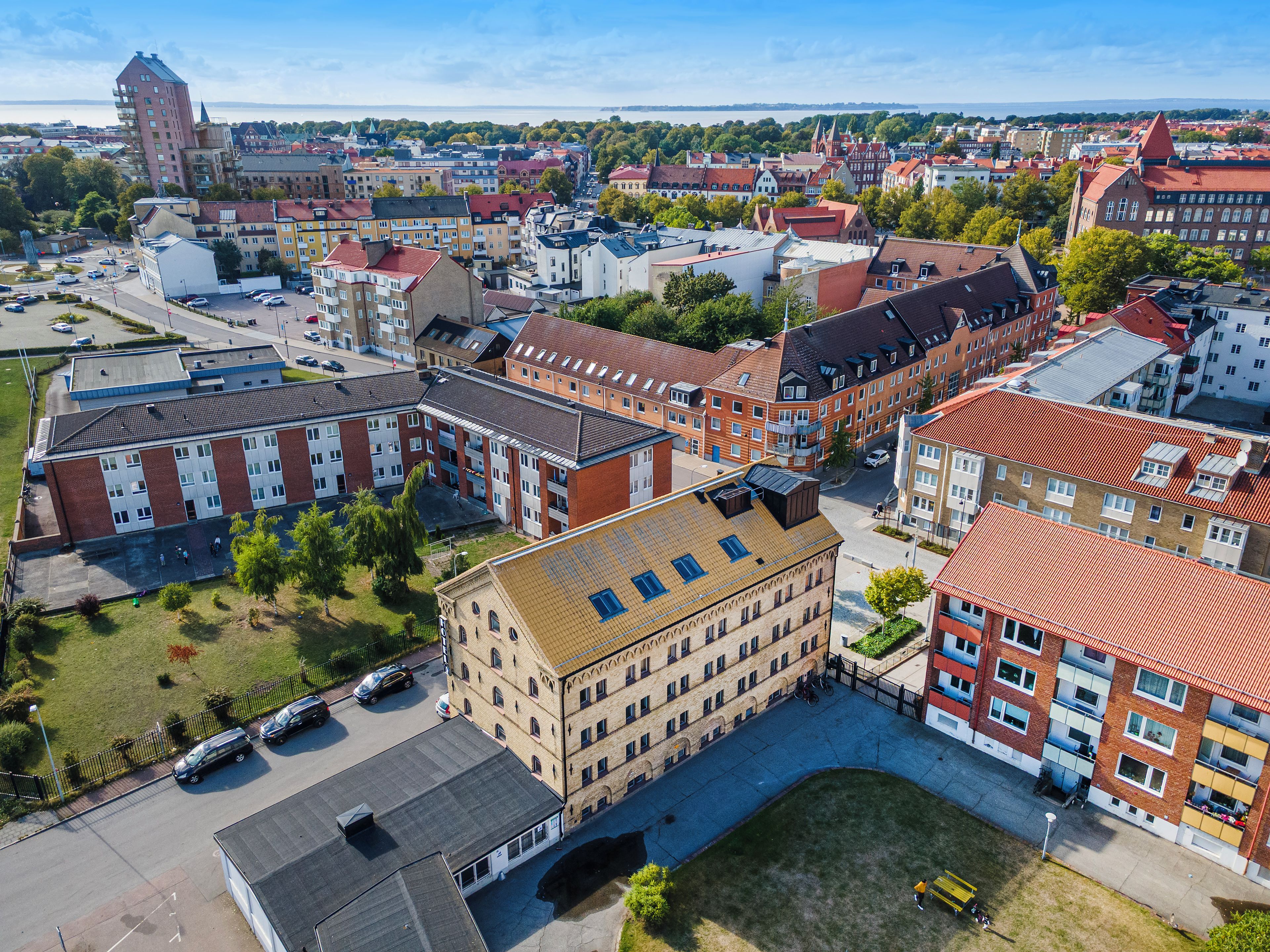 En byggnad med flera våningar och en central innergård, omgiven av andra byggnader.