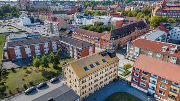 En byggnad med flera våningar och en central innergård, omgiven av andra byggnader.