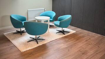 A modern room with a skylight, a round table, and four blue chairs.