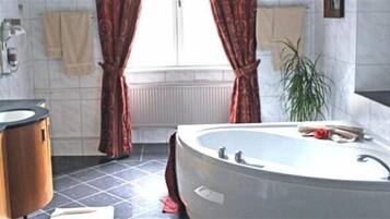 Un baño con bañera, lavabo y espejo.