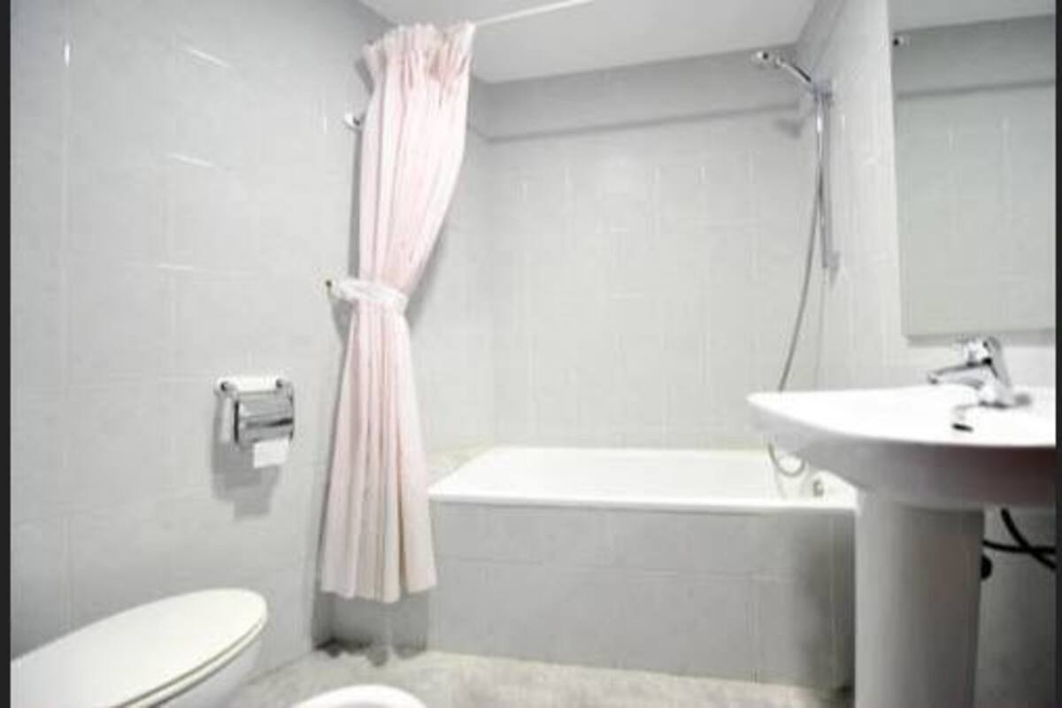 A bathroom with a toilet, a bathtub, and a sink.