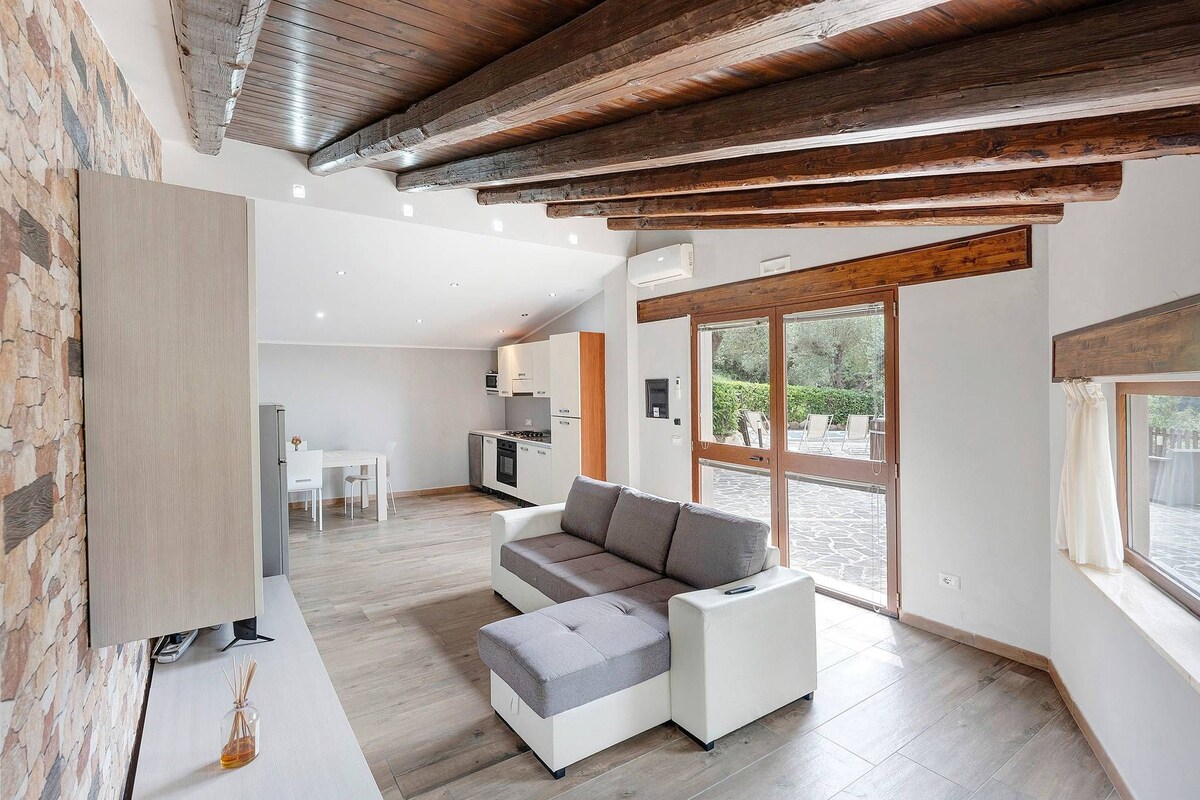 A modern living room with a sectional sofa, a flat-screen TV, and a stone accent wall.