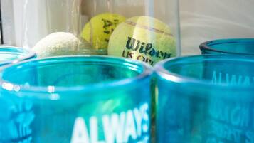 A close-up of tennis balls in a container with blue glasses labeled "ALWAYS".