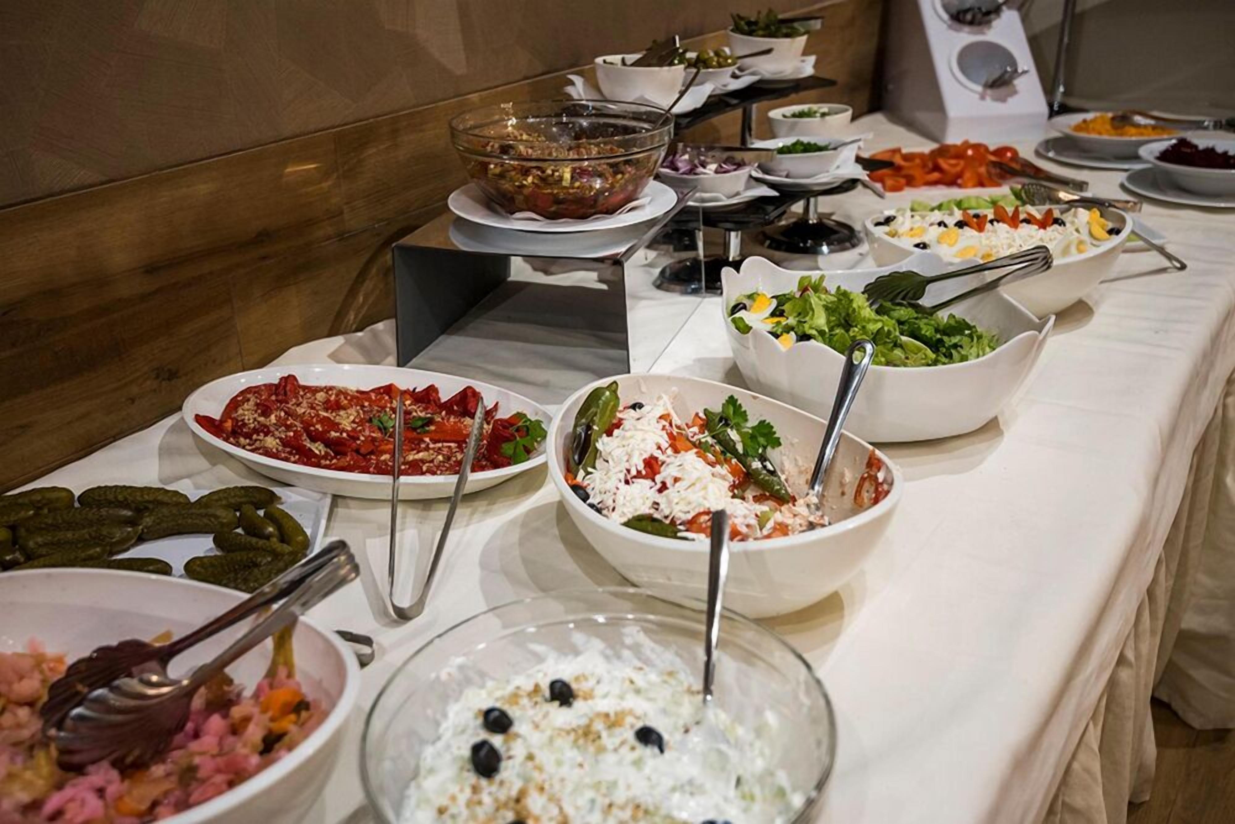 Un bufé con diversos platos, entre ellos ensaladas, arroz y encurtidos.