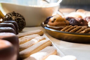 A variety of baked goods including cookies, muffins, and chocolate-covered items on display.