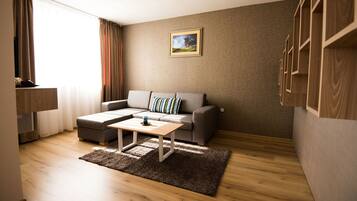 Un salon moderne avec un canapé gris, une table basse en bois et un tapis marron.
