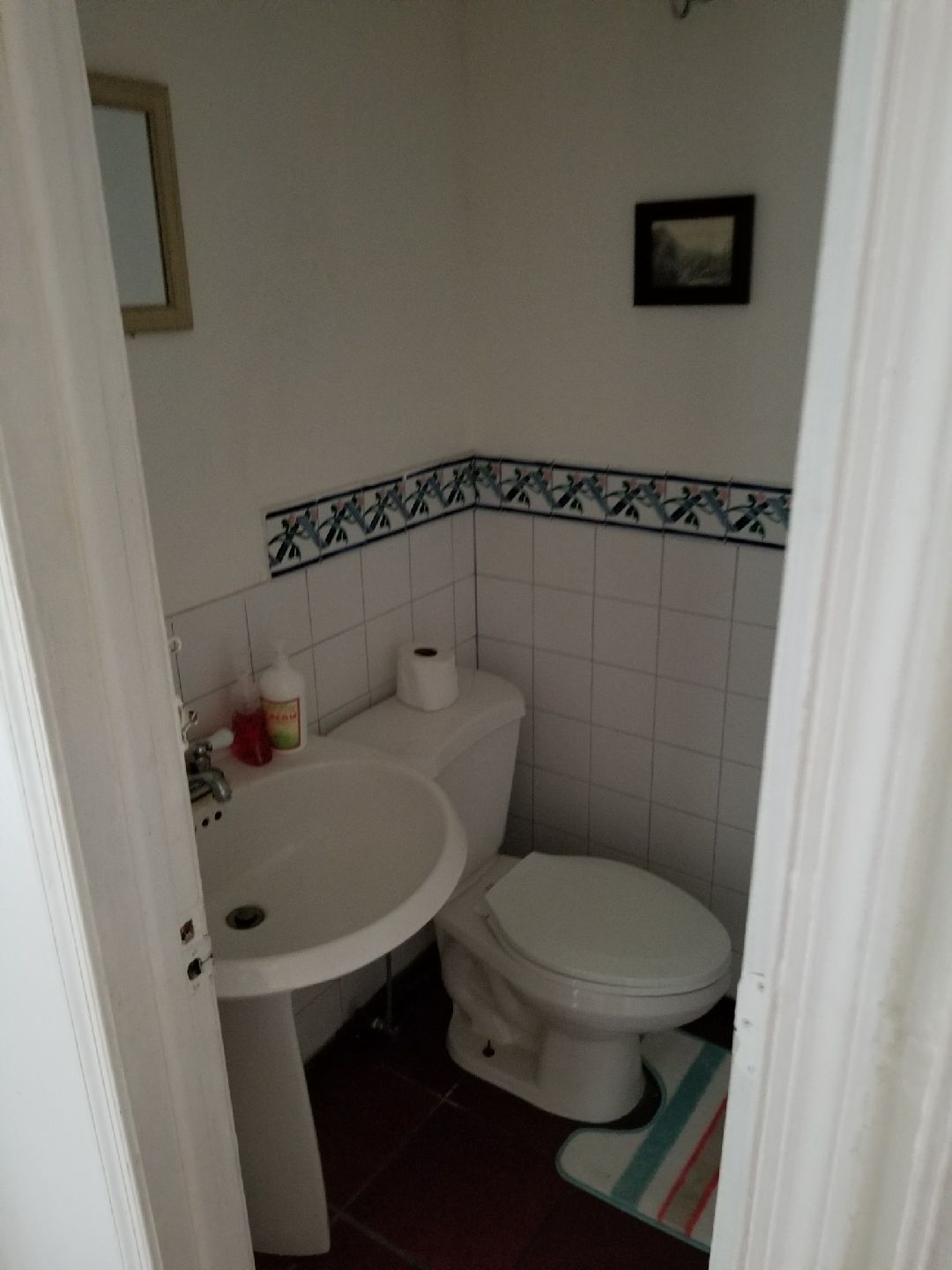 Une petite salle de bain avec un lavabo, des toilettes et un miroir.