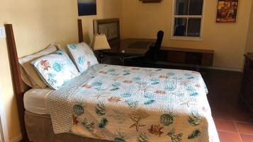 Un dormitorio con cama, escritorio y silla.