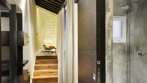 Ein modernes Interieur mit einer Holztreppe, einer Duschkabine aus Glas und einer Wand mit einem motivierenden Zitat.