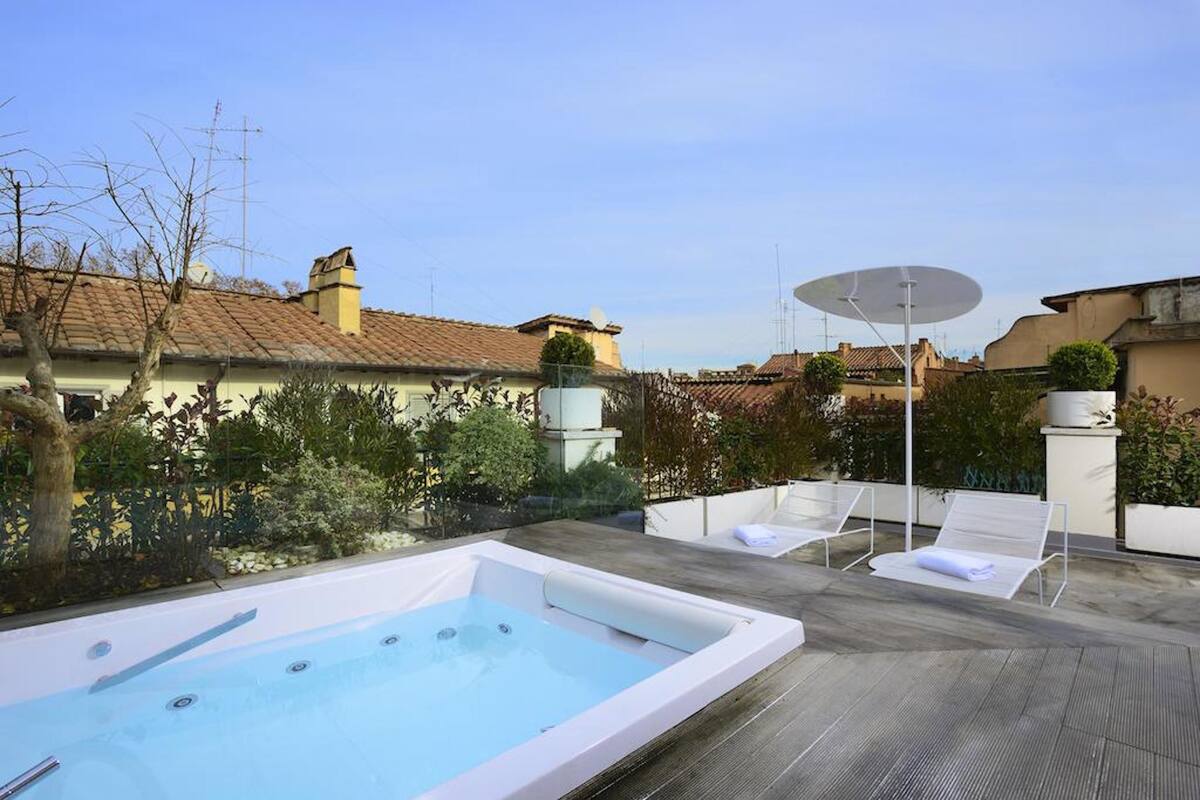 Zona de piscina en la azotea con jacuzzi, sillas de descanso y antena parabólica.