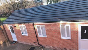 A red brick building with a grey roof, numbered 2, featuring a small porch and a door with a window. - Two bedrooms self-contained flat with Free Parking - Flat 2 (Nottingham)