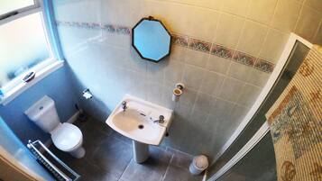Un baño con inodoro, lavamanos y espejo.