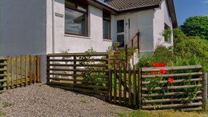 A white house with a tiled roof, a wooden gate, and a gravel driveway. - Steading Holidays - Ardvaig (Acharacle)