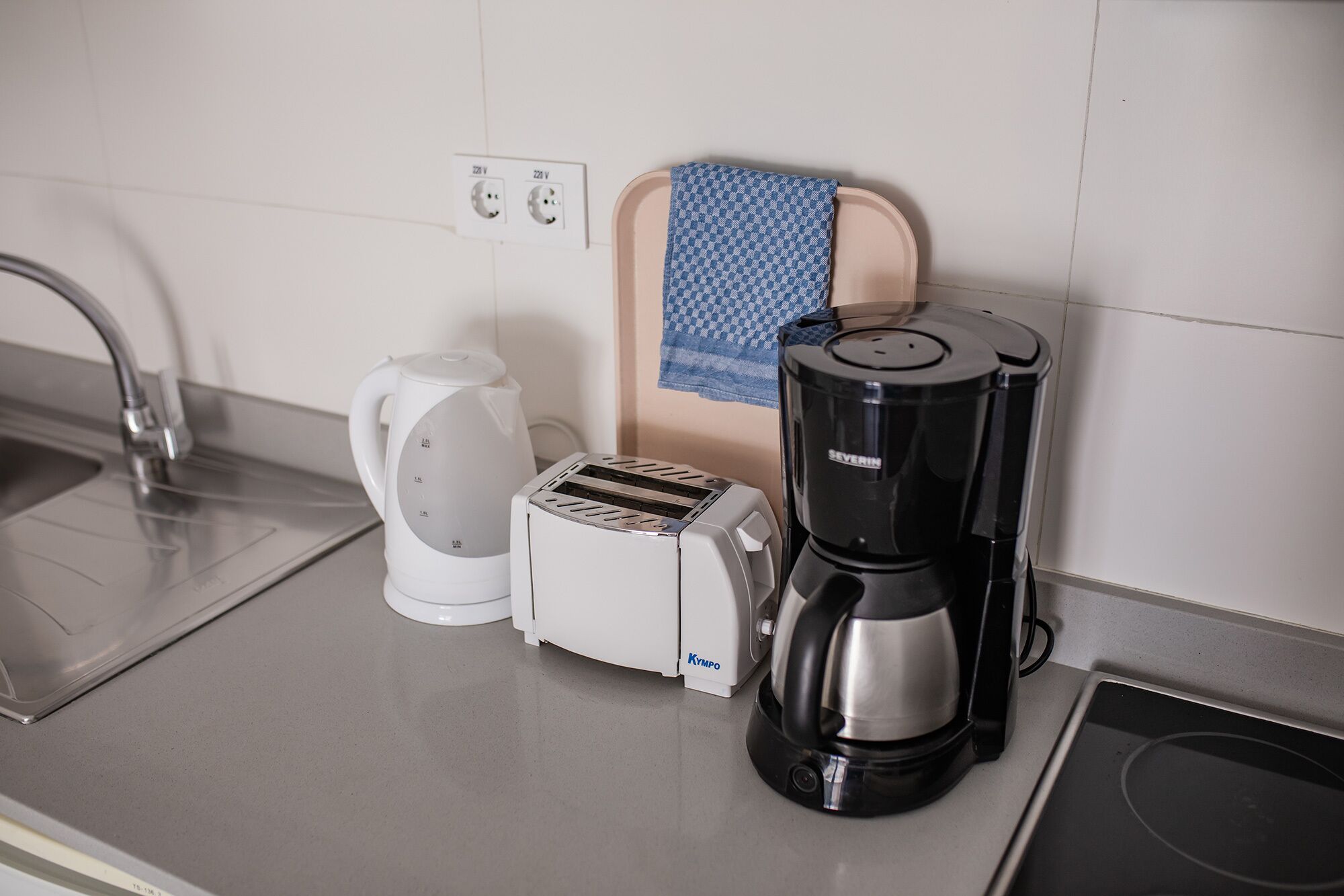 A kitchen with a coffee maker, toaster, and kettle on the counter.
